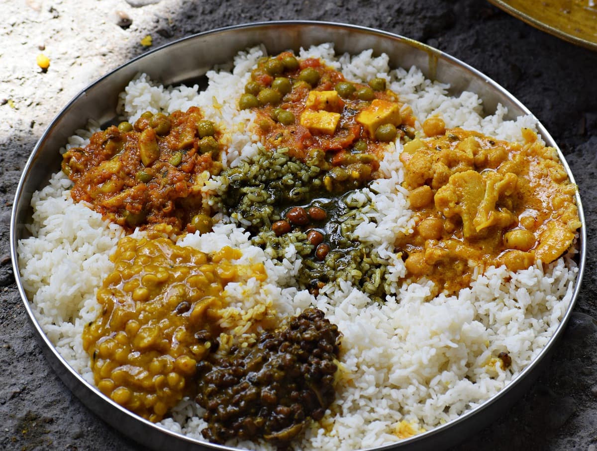 Scoops of different foods on a bed of rice