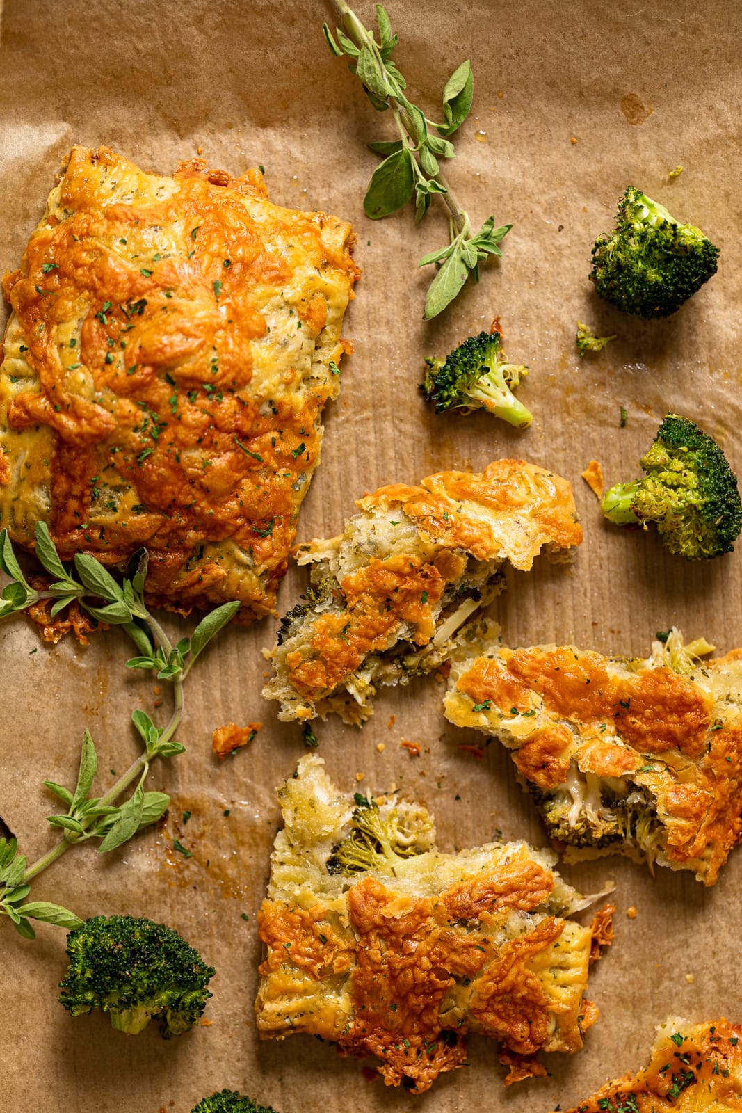 Broccoli Cheddar Hand Pies and broccoli on parchment paper