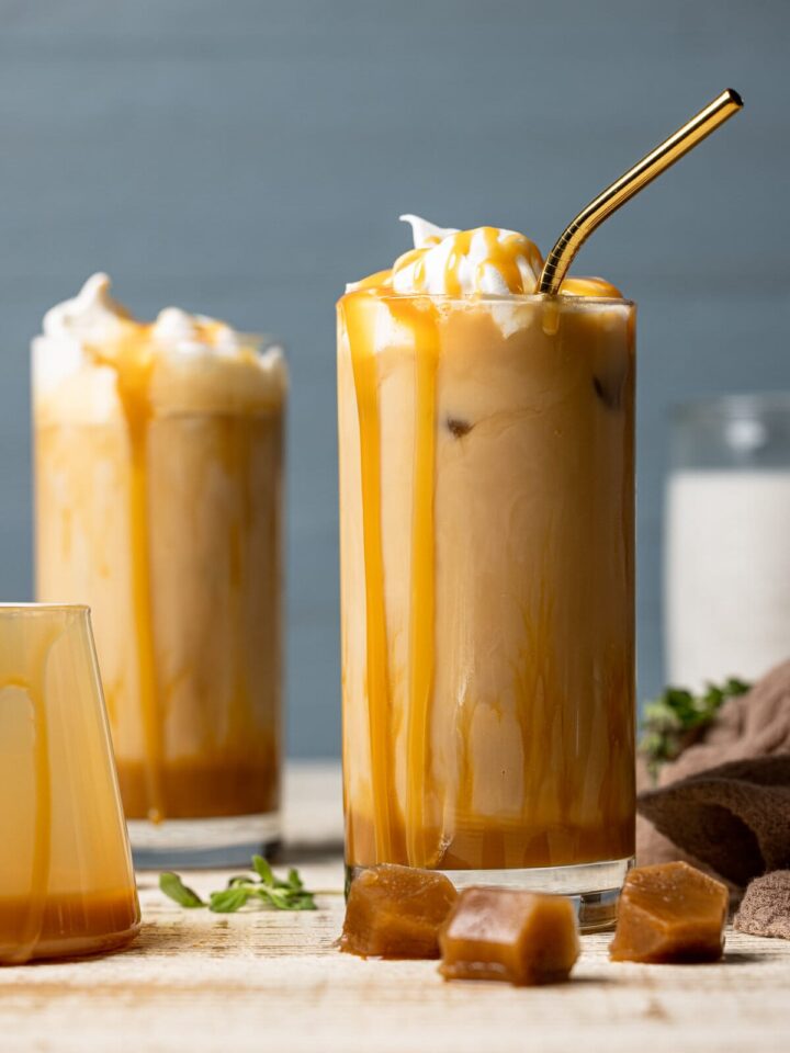 Two iced caramel lattes with caramel dripping down the sides