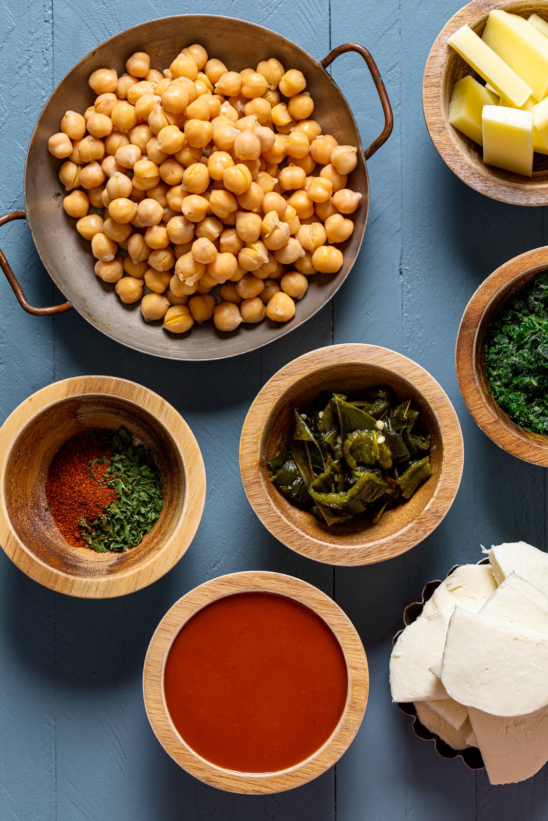 Ingredients for Sheet Pan Roasted Garlic Buffalo Chickpea Pizza including buffalo sauce, chickpeas, and kale