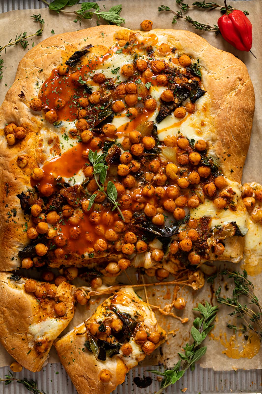 Cooked Sheet Pan Roasted Garlic Buffalo Chickpea Pizza with a few slices cut