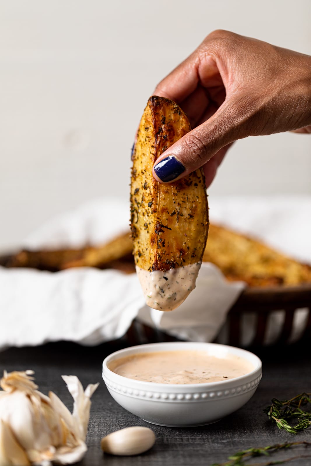 Hand dipping a Crispy Jumbo Garlic Herb Fry