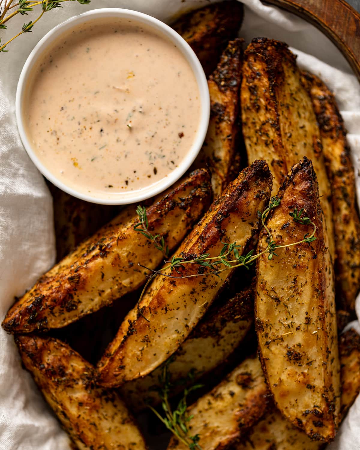 Overhead shot of a basket of Crispy Jumbo Garlic Herb Fries with dip