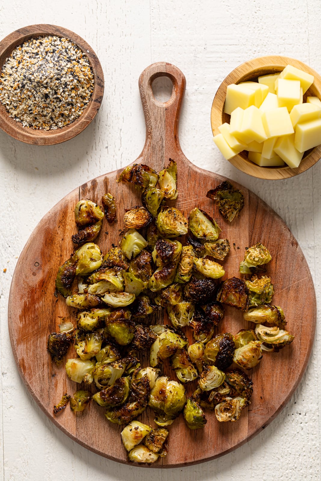 Chopped, roasted brussels sprouts next to everything seasoning and mozzarella cheese