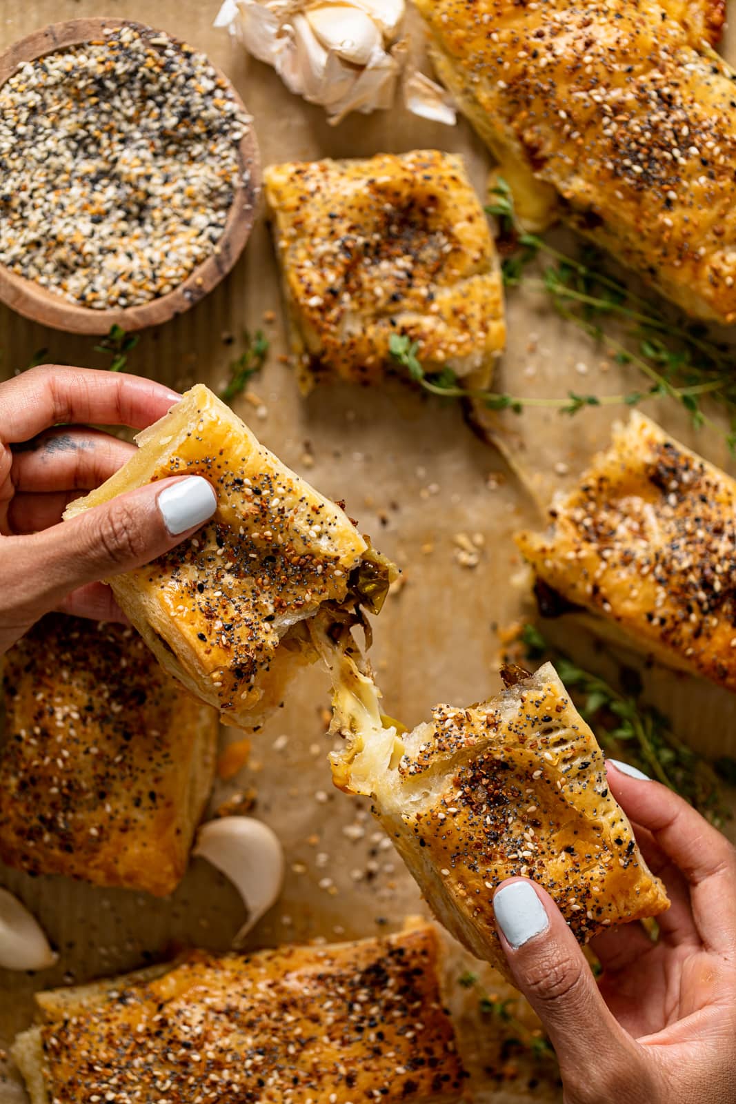 Hands pulling apart an Everything Brussels Sprouts and Mozzarella Hand Pie