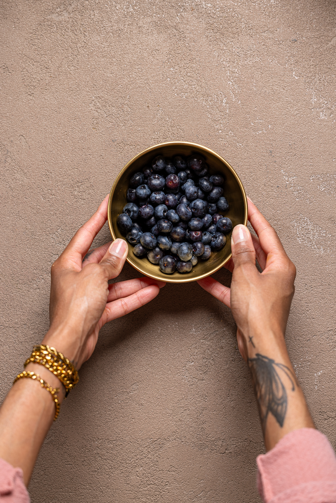 Image of fresh blueberries in a bowl being held by hands.