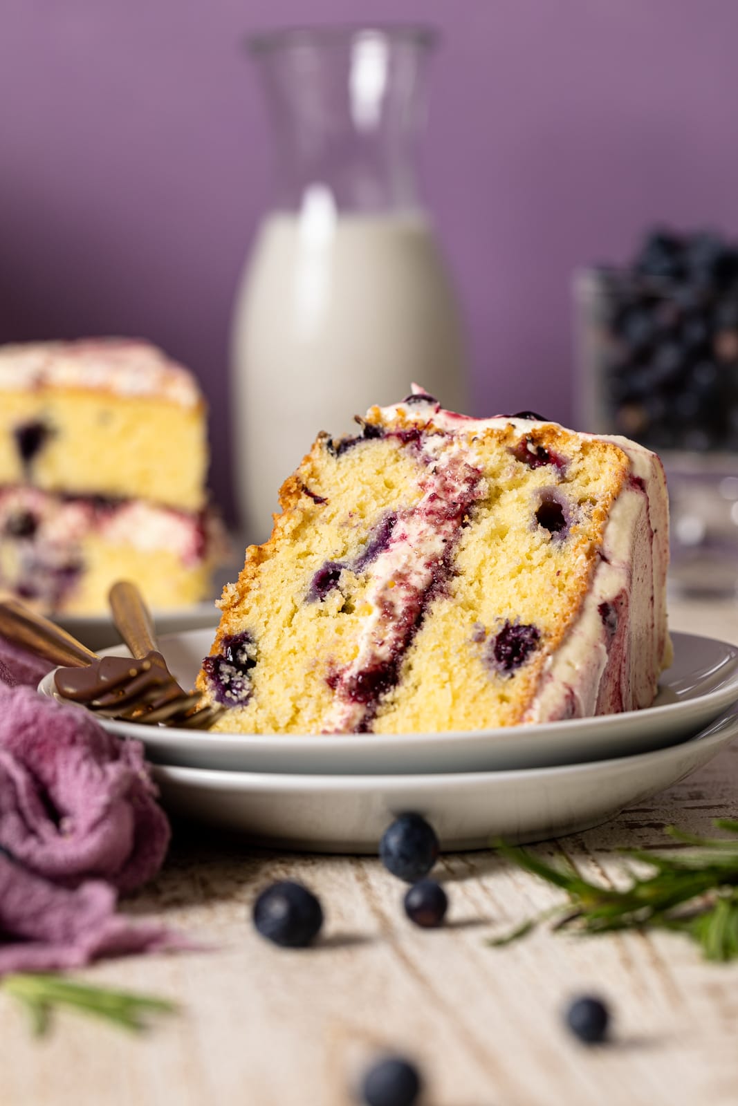 Slice of Lemon Blueberry Olive Oil Cake on two stacked plates