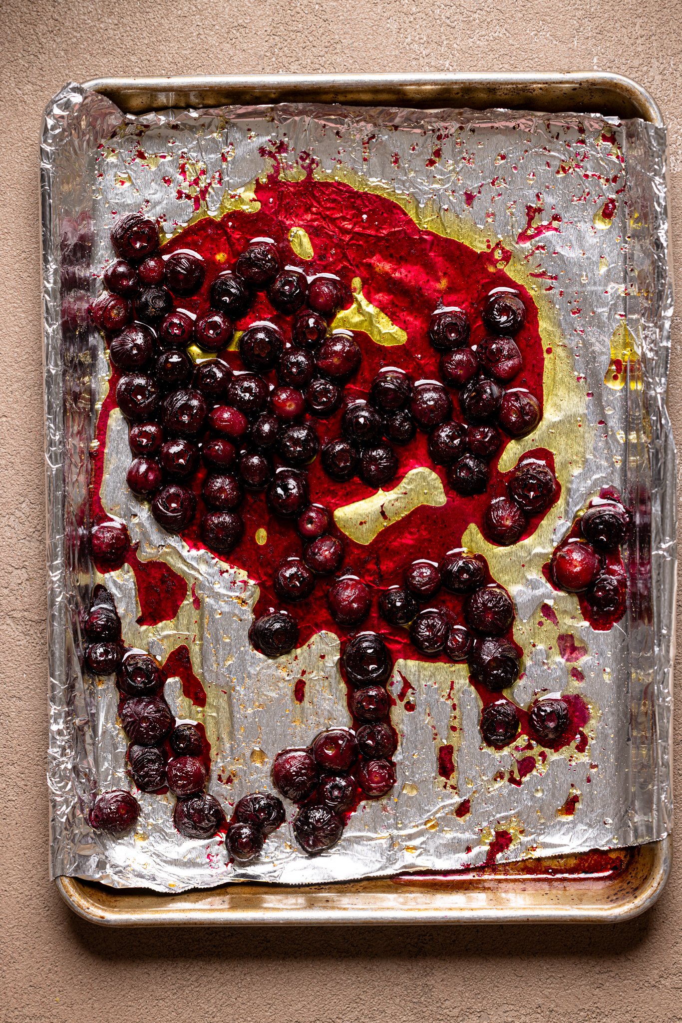 Image of roasted blueberries on a baking sheet with foil.