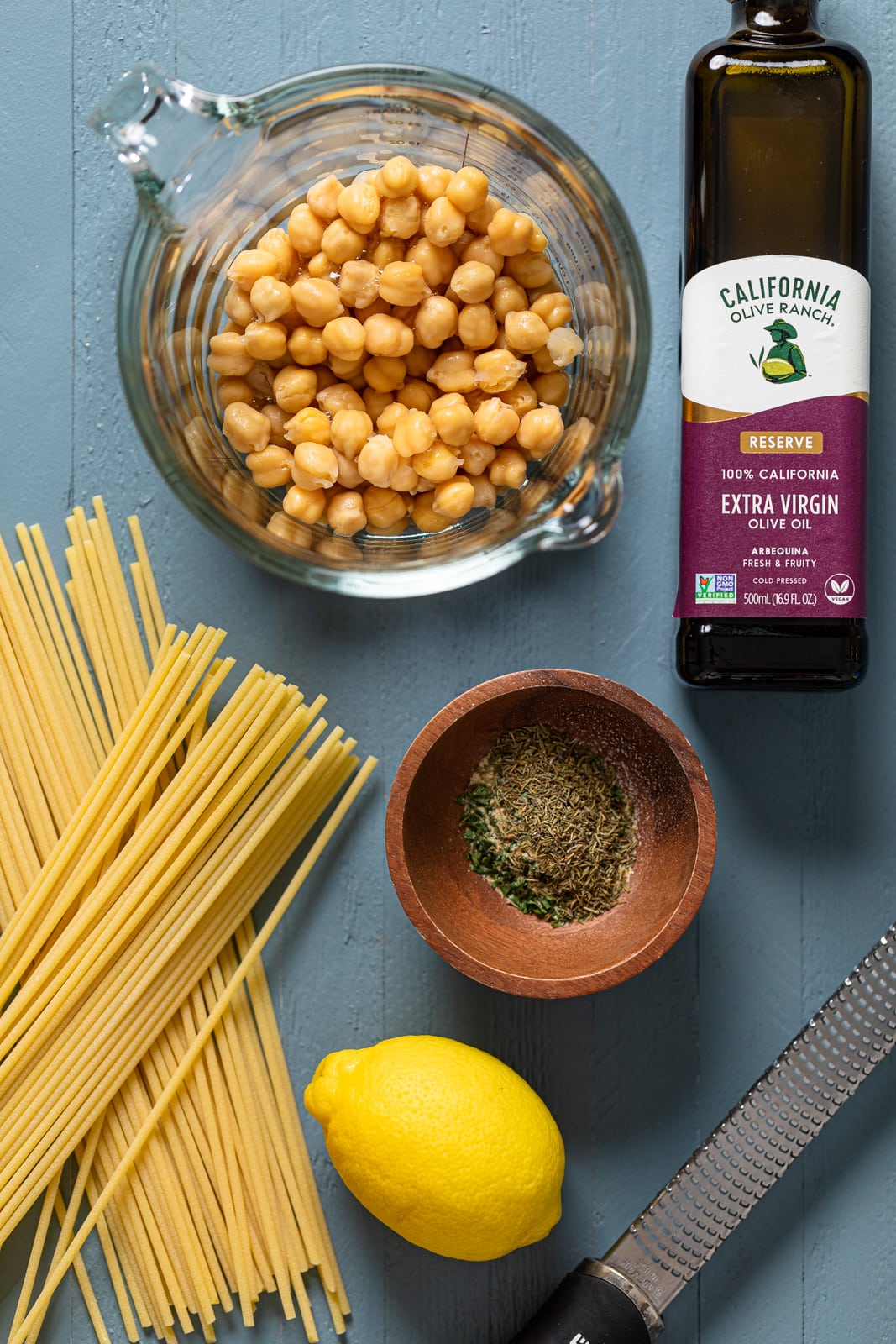 Ingredients for Lemon Herb Roasted Chickpeas and Bucatini including a lemon, olive oil, and chickpeas
