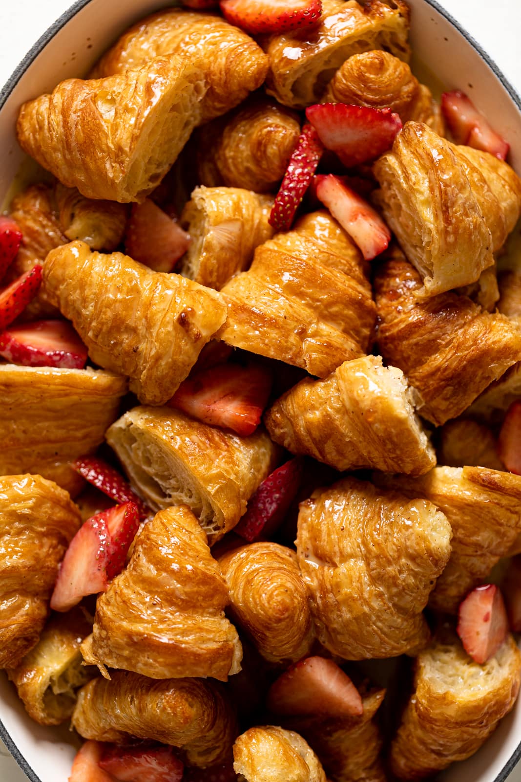Closeup of sliced strawberries mixed with croissant pieces