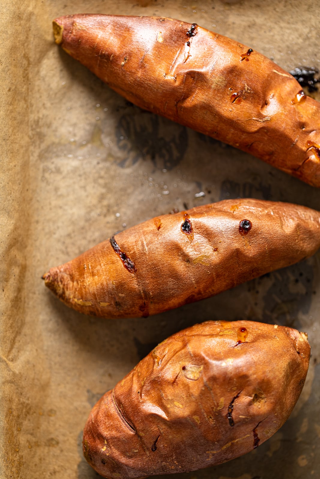 Roasted sweet potatoes on parchment paper, ready to become the perfect weeknight vegan meal