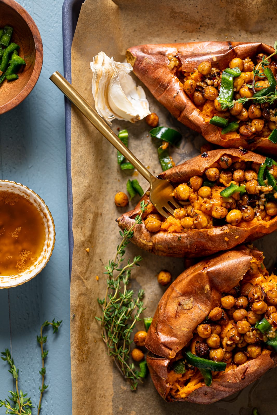Three Spiced Chickpea Stuffed Sweet Potatoes with a fork sticking out of one. The perfect vegan weeknight meal.
