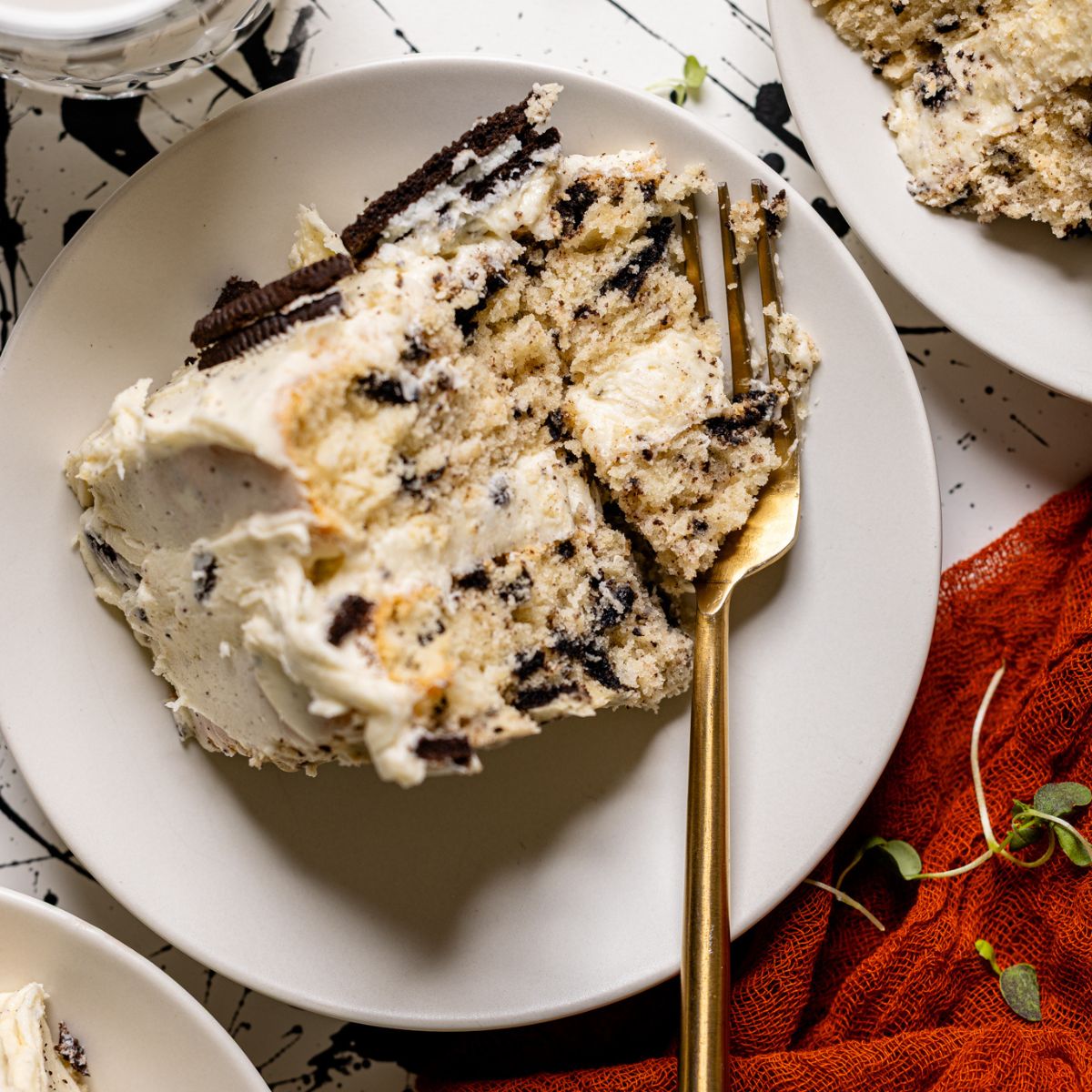 Up close of Oreo Cake slice on a white plate with a fork.