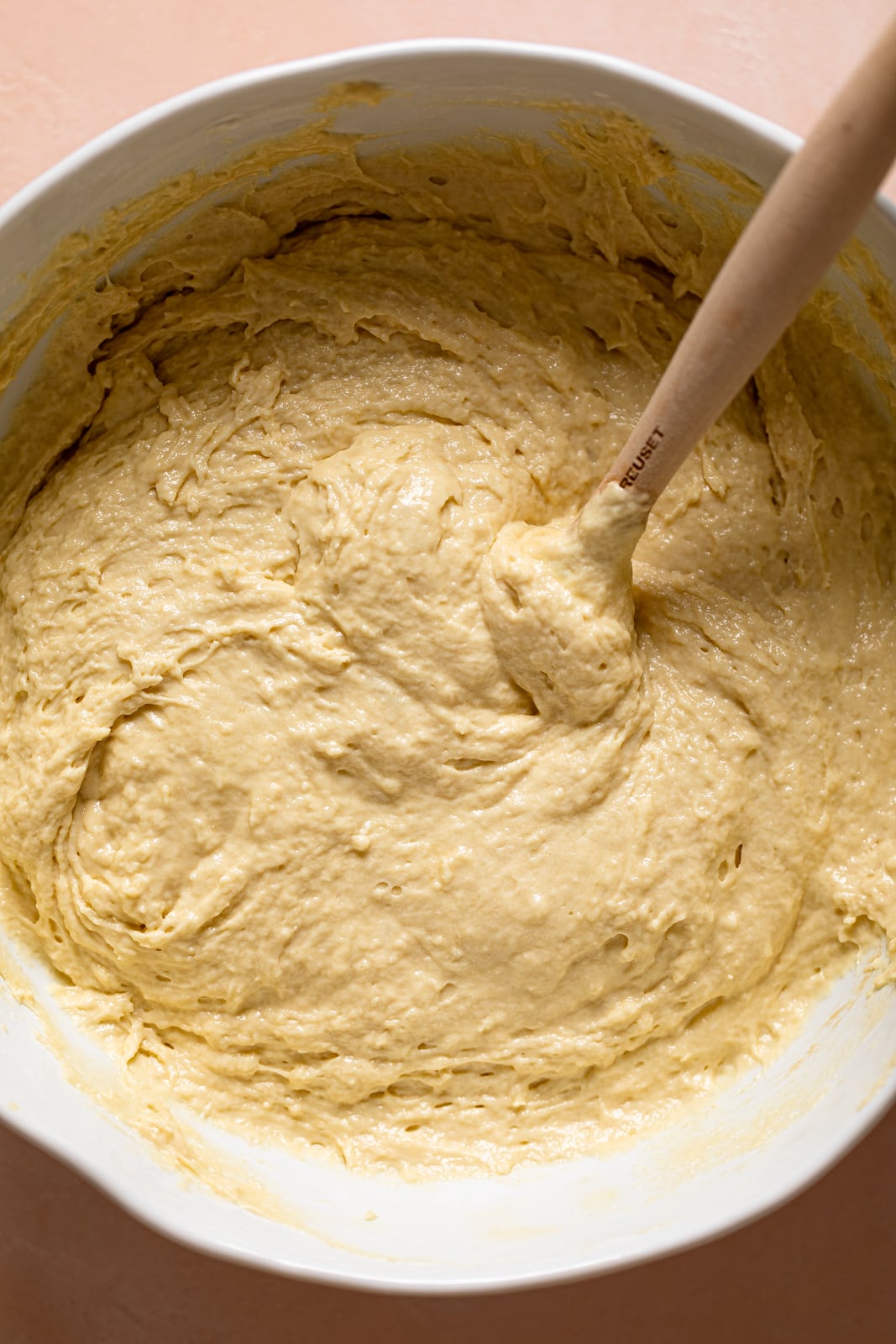 Wooden spoon stirring a bowl of Vanilla Yogurt Cake batter