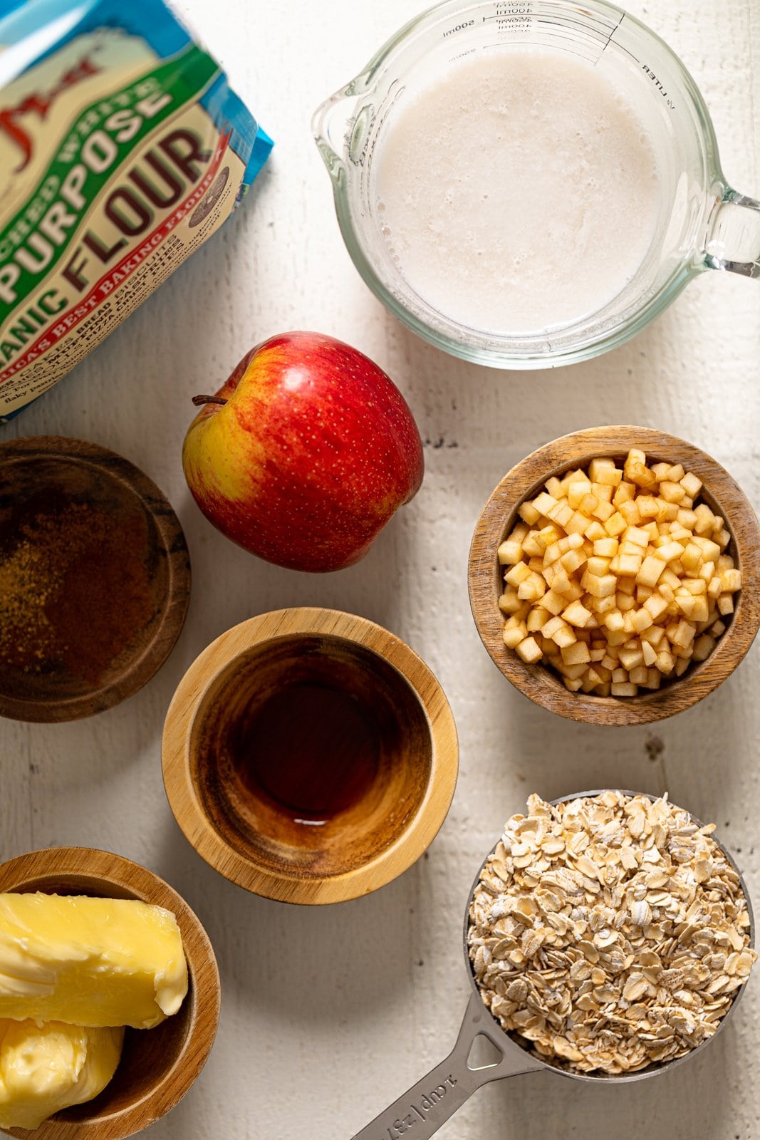 Ingredients for Vegan Apple Oatmeal Sheet Cake including organic flour, oats, and an apple