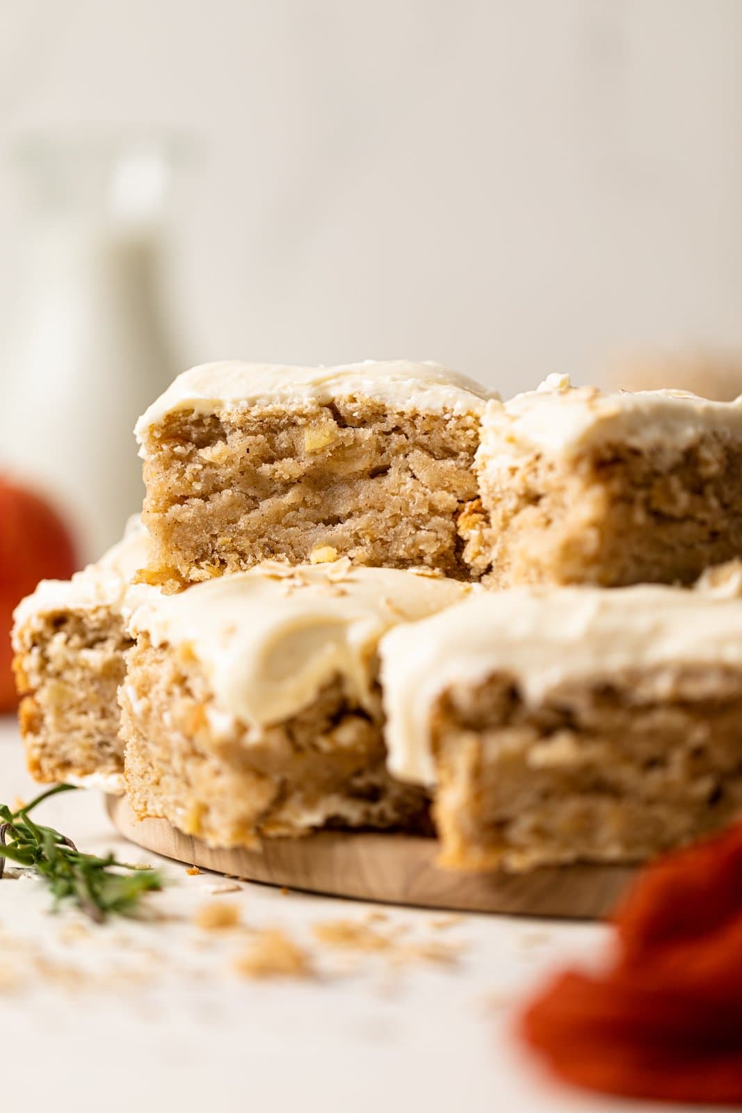 Slices of Vegan Apple Oatmeal Sheet Cake stacked on a wooden serving platter