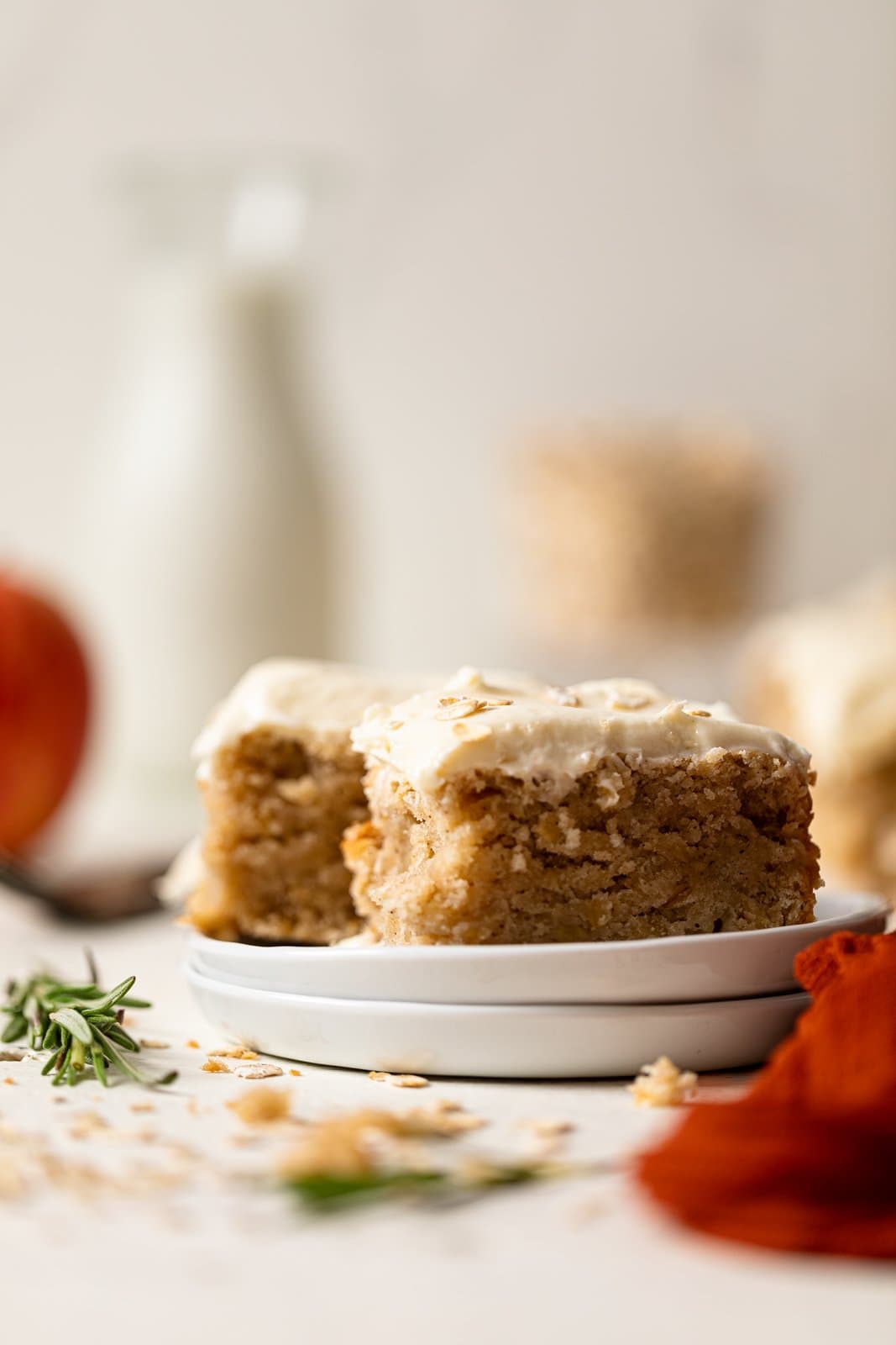 Slices of Vegan Apple Oatmeal Sheet Cake on two stacked plates