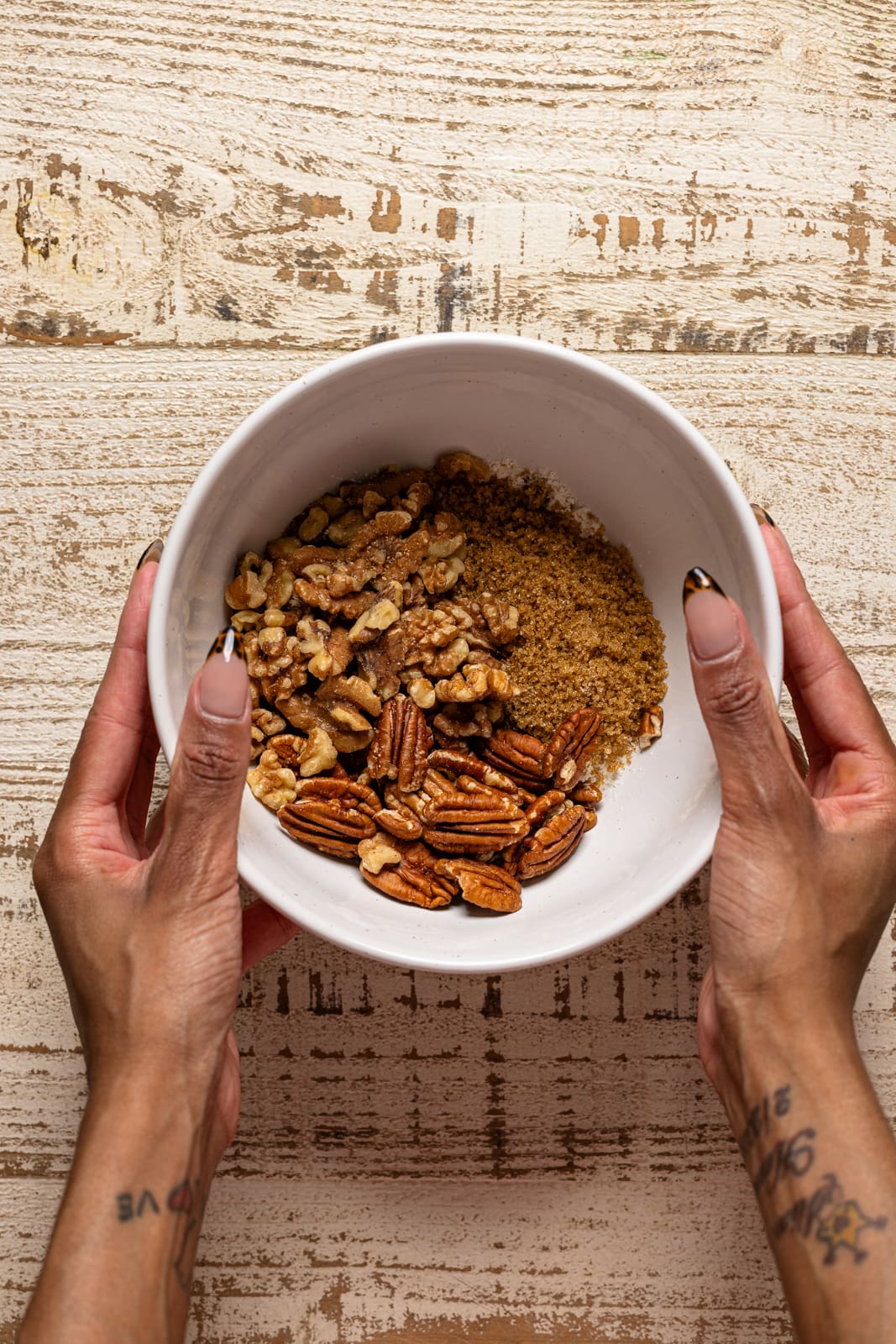 Topping ingredients in a white bowl being held.