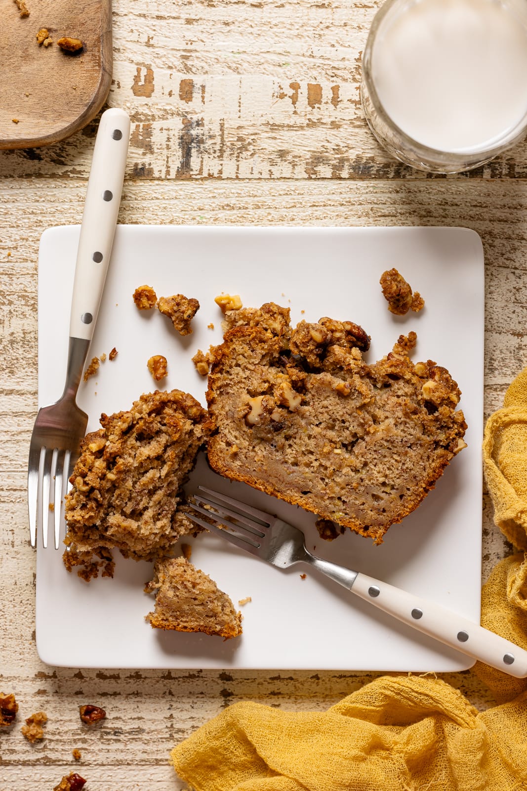 Slice of banana bread on a white plate with two forks.