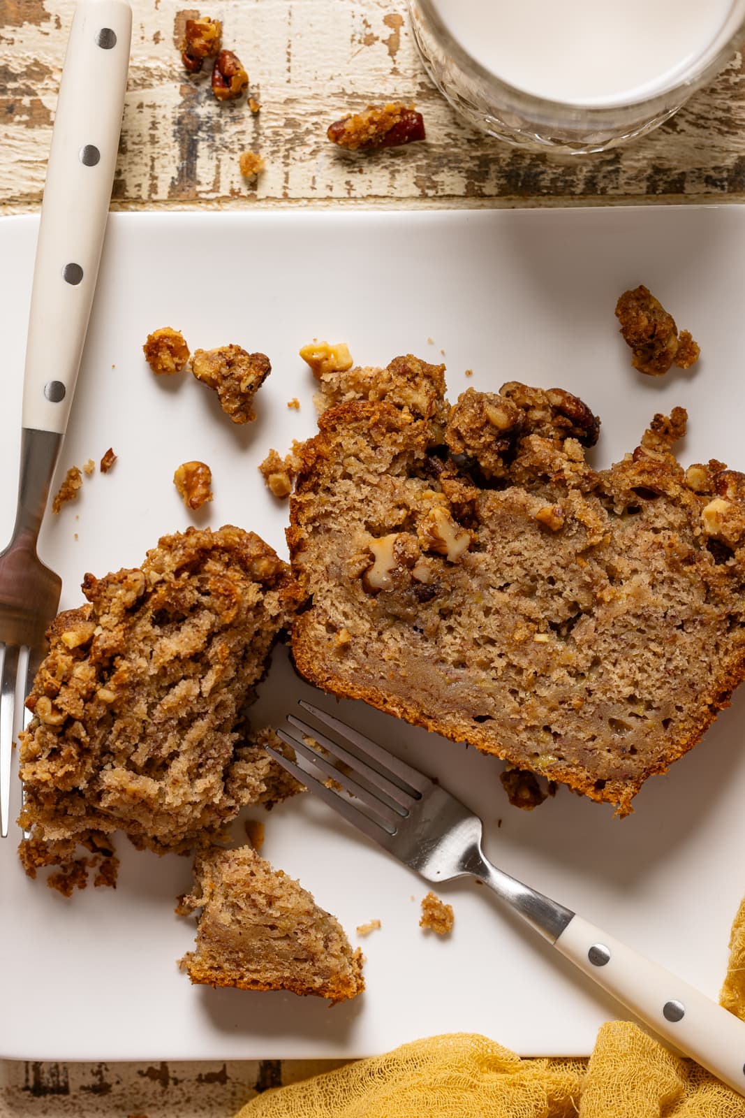 Up close shot of banana bread on a white plate with two forks.