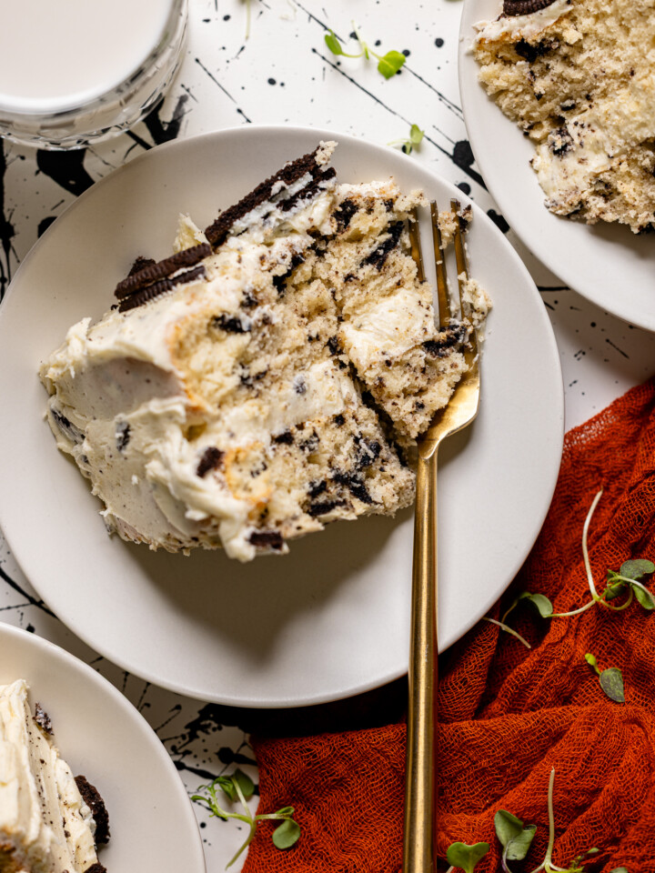 Up close of Oreo Cake slice on a white plate with a fork.