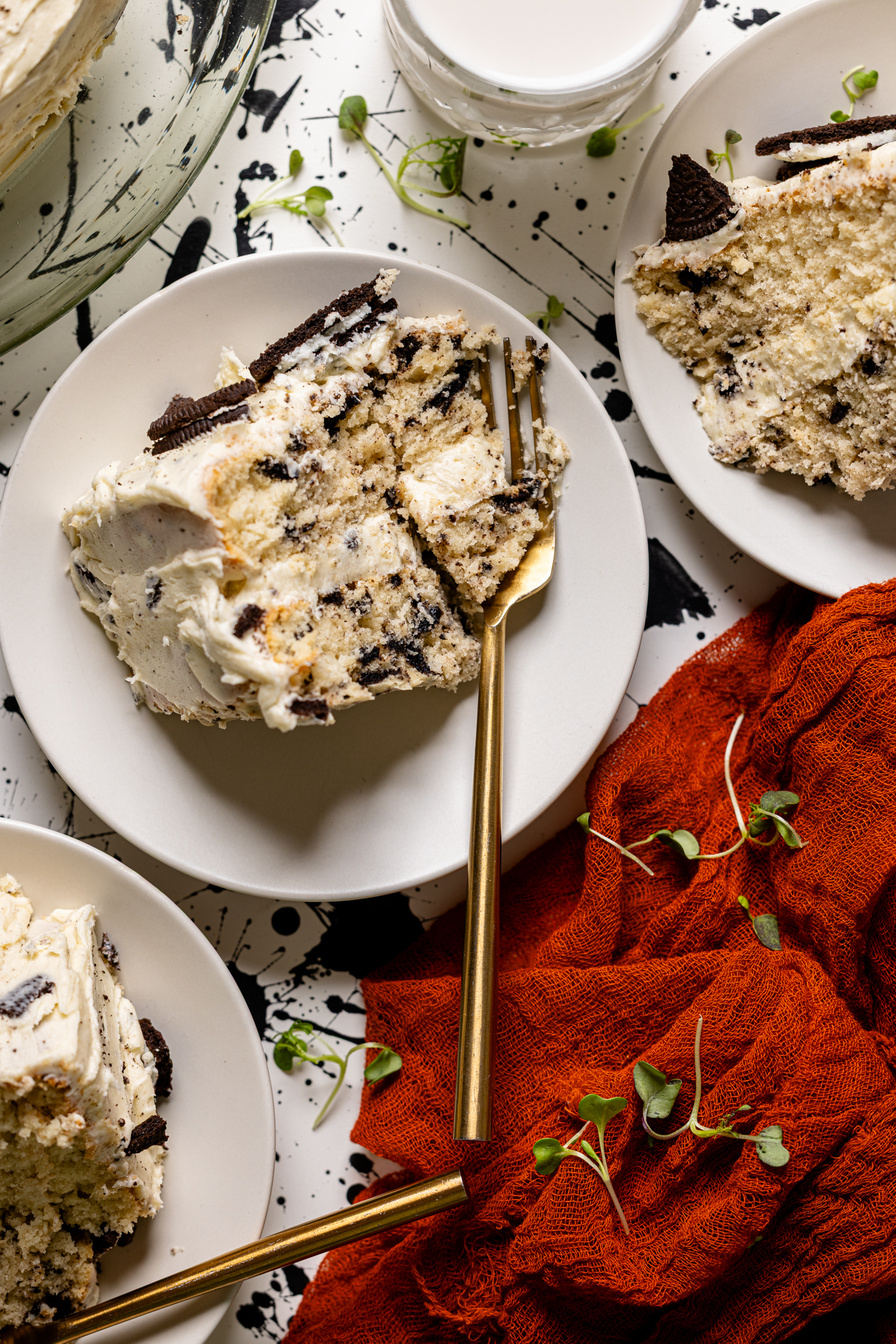 An image of three plates with slices of Oreo Cake with forks and a red napkin.