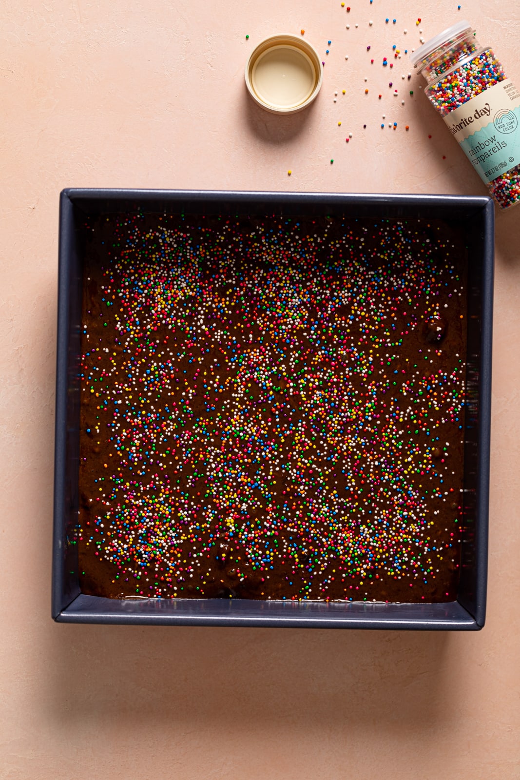 Baking pan of Vegan Zucchini Brownie batter topped with sprinkles