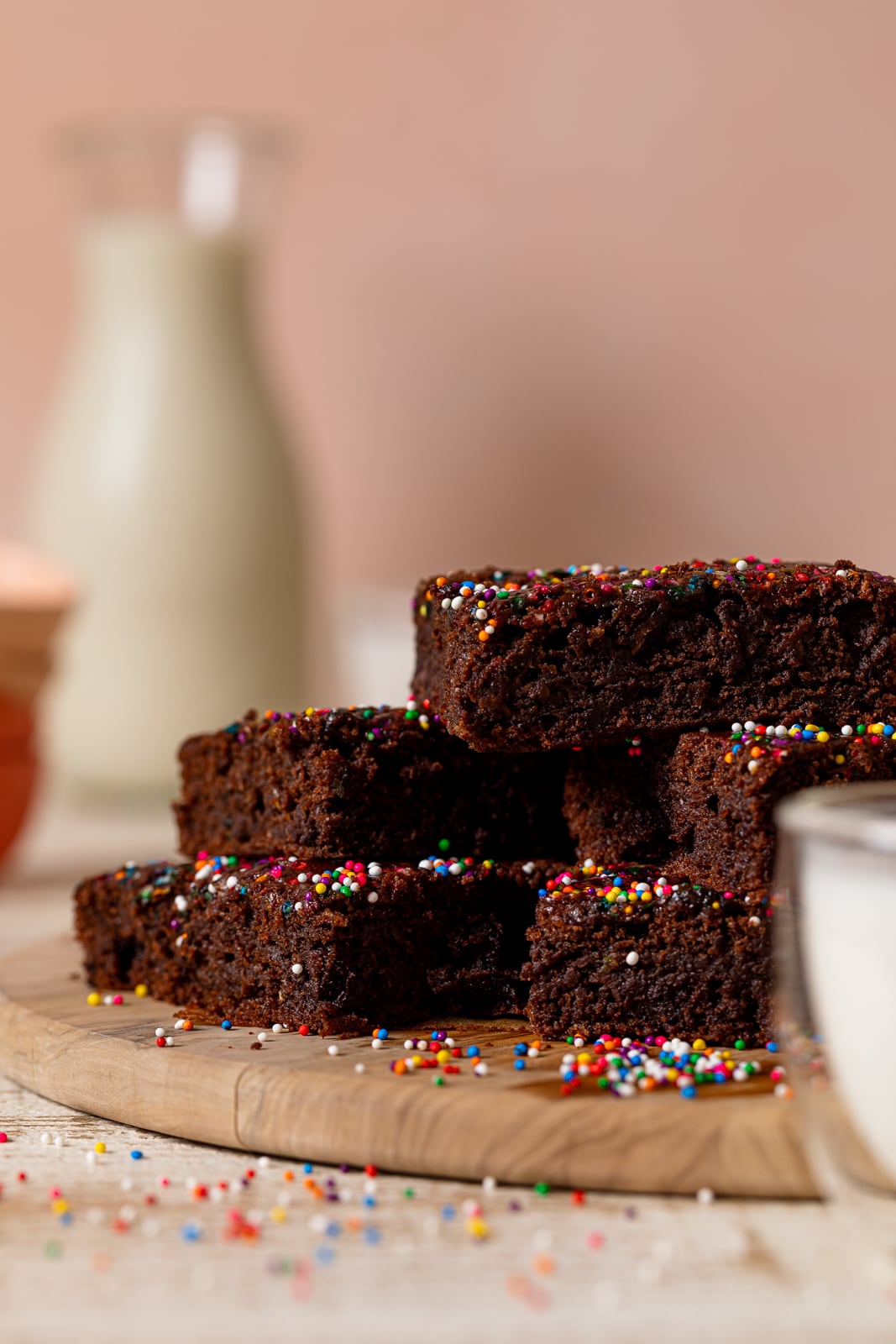 Side view of Vegan Zucchini Brownies piled on a wooden platter