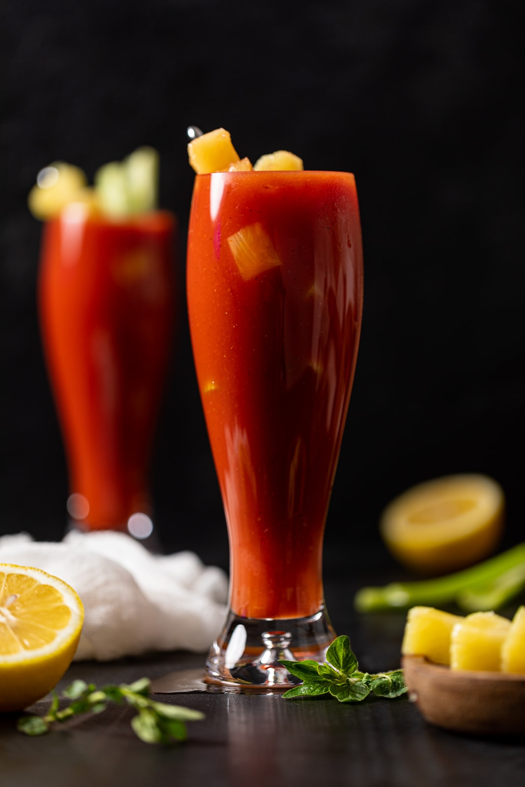 Two tall Bloody Mary Mocktails near lemon halves