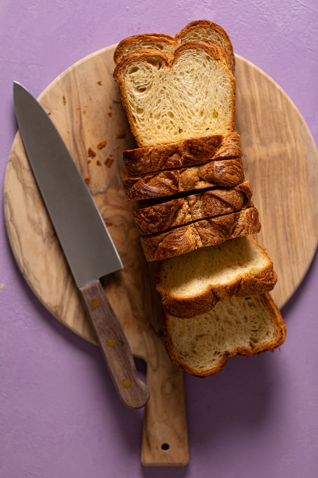 Sliced brioche bread on a cutting board with a knife