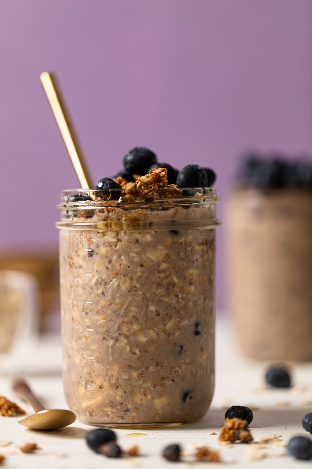 Spoon sticking out of a mason jar of Protein Loaded Blueberry Overnight Oats