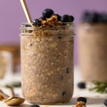 Spoon sticking out of a mason jar of Protein Loaded Blueberry Overnight Oats