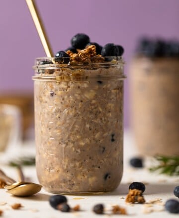 Spoon sticking out of a mason jar of Protein Loaded Blueberry Overnight Oats