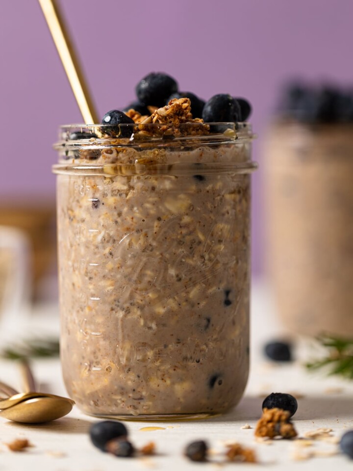 Spoon sticking out of a mason jar of Protein Loaded Blueberry Overnight Oats