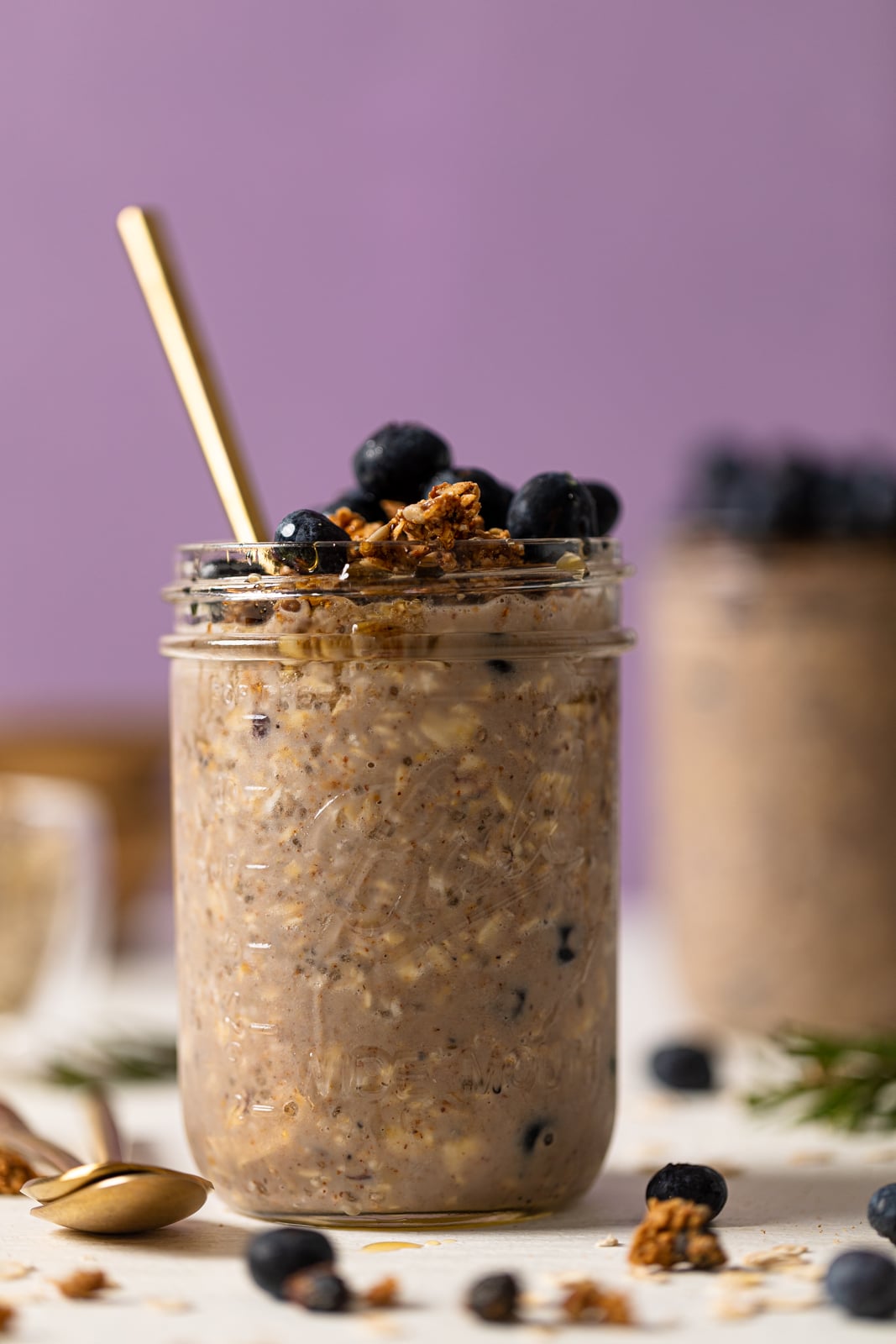 Spoon sticking out of a mason jar of Protein Loaded Blueberry Overnight Oats