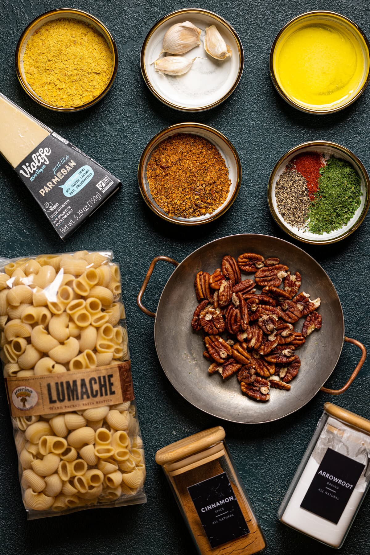 Ingredients for Southern-Style Cajun Pasta with Pecan Breadcrumbs including vegan parmesan, cinnamon, spices, and pasta