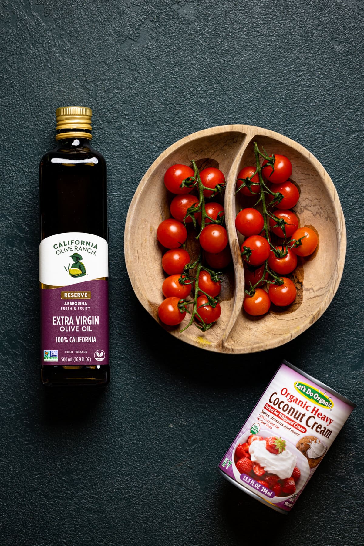 Wooden bowl of cherry tomatoes, olive oil, and heavy coconut cream