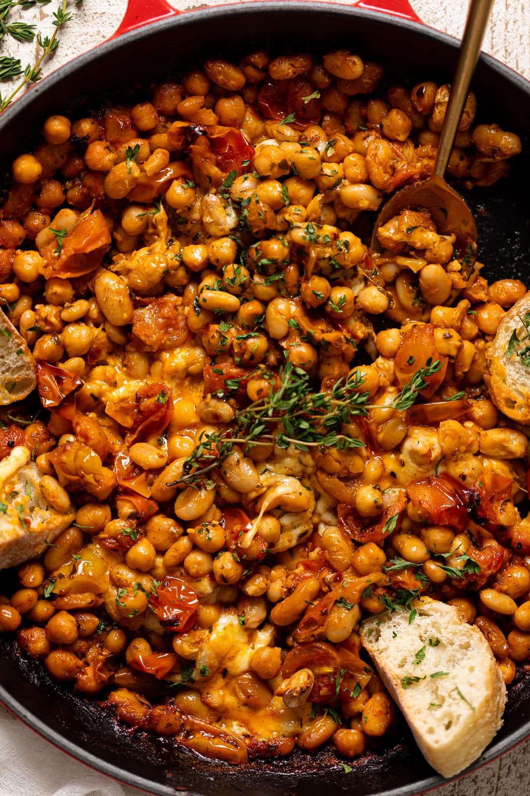 Closeup of Saucy Baked Chickpea and White Beans with a spoon