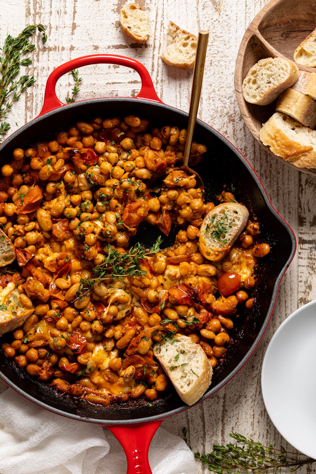 Overhead shot of a skillet of Saucy Baked Chickpea and White Beans