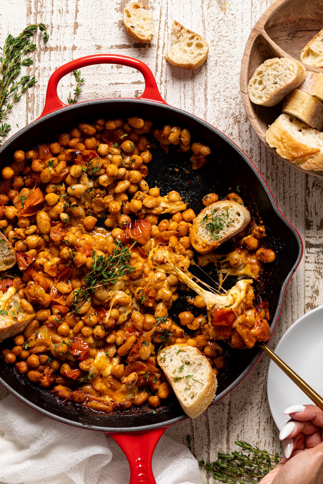 Overhead shot of a skillet of Saucy Baked Chickpea and White Beans