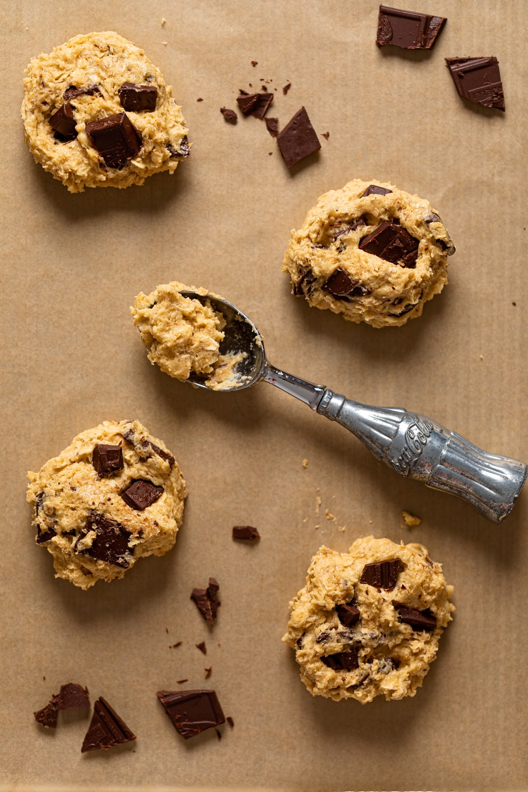 Balls of Oatmeal Chocolate Chip Cookie dough on parchment paper