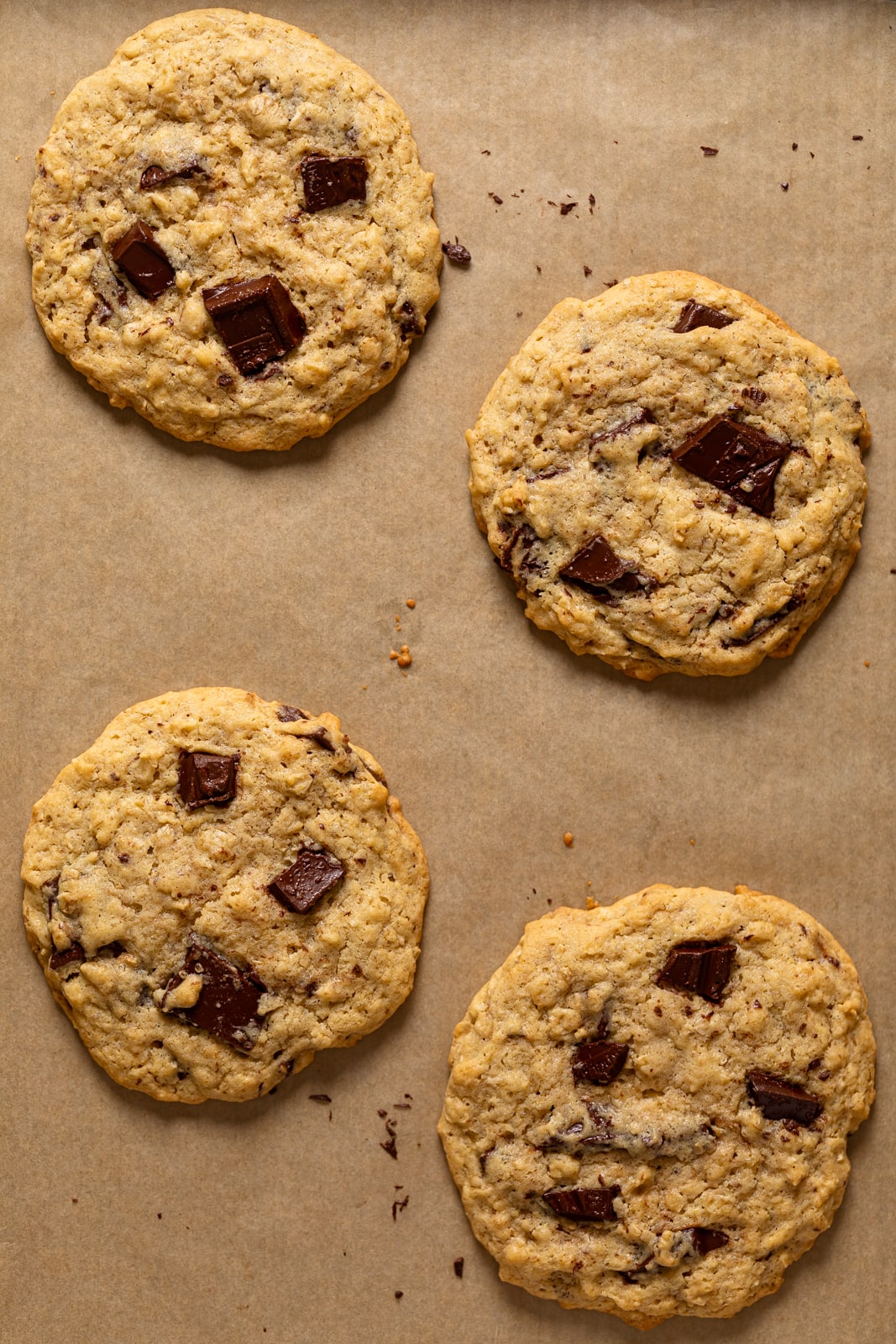 Overhead shot of Bakery-Style Oatmeal Chocolate Chip Cookies on parchment paper