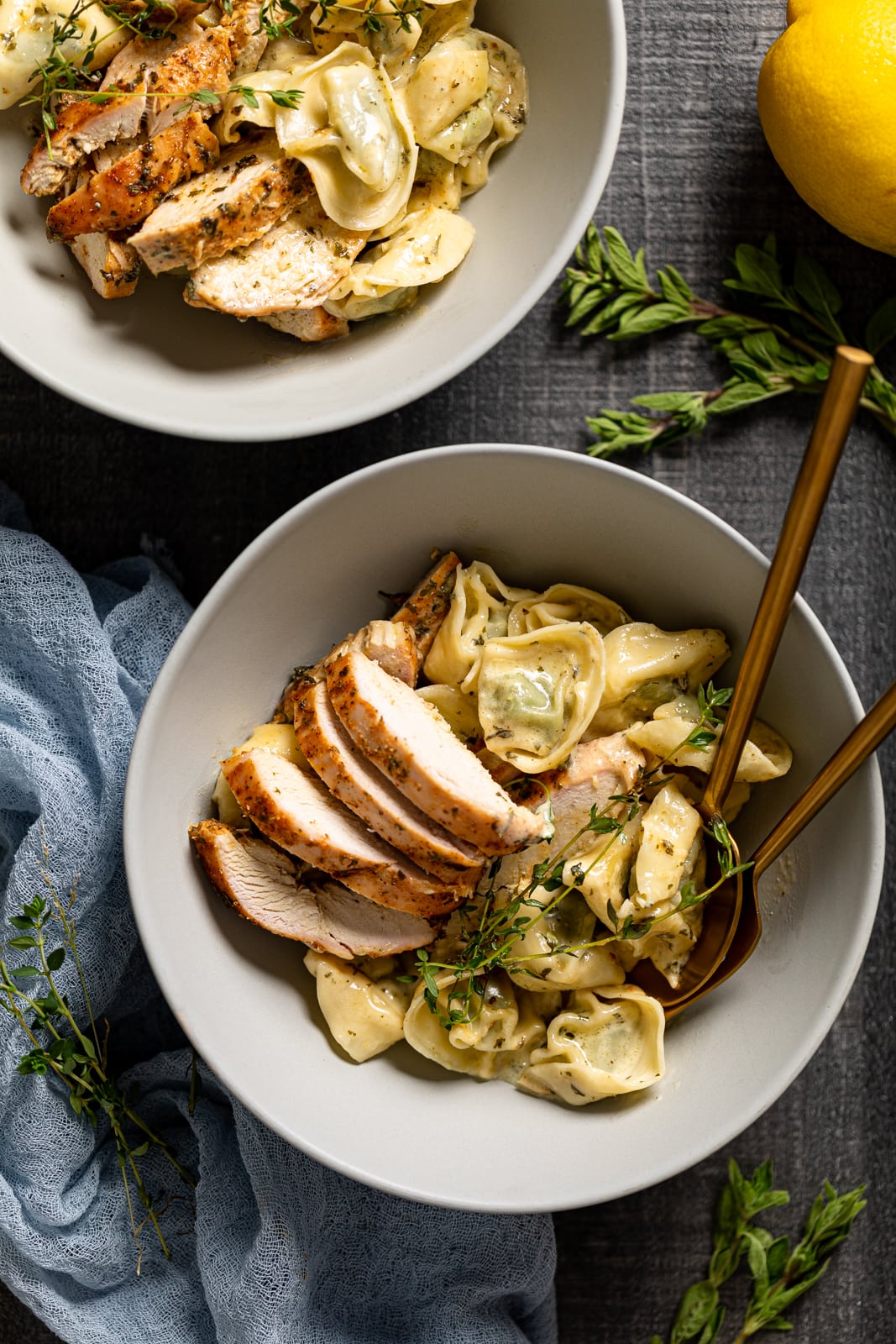 Two bowls of Creamy Lemon Herb Roasted Chicken with Spinach Tortellini 