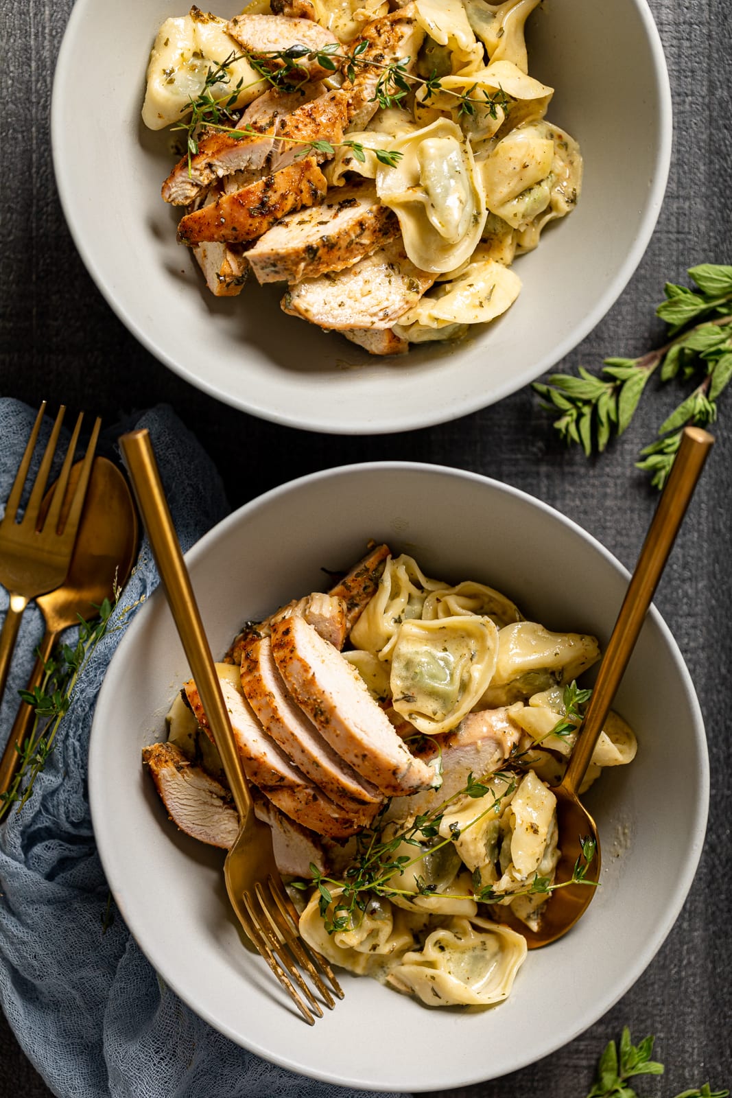 Overhead shot of two bowls of Creamy Lemon Herb Roasted Chicken with Spinach Tortellini 