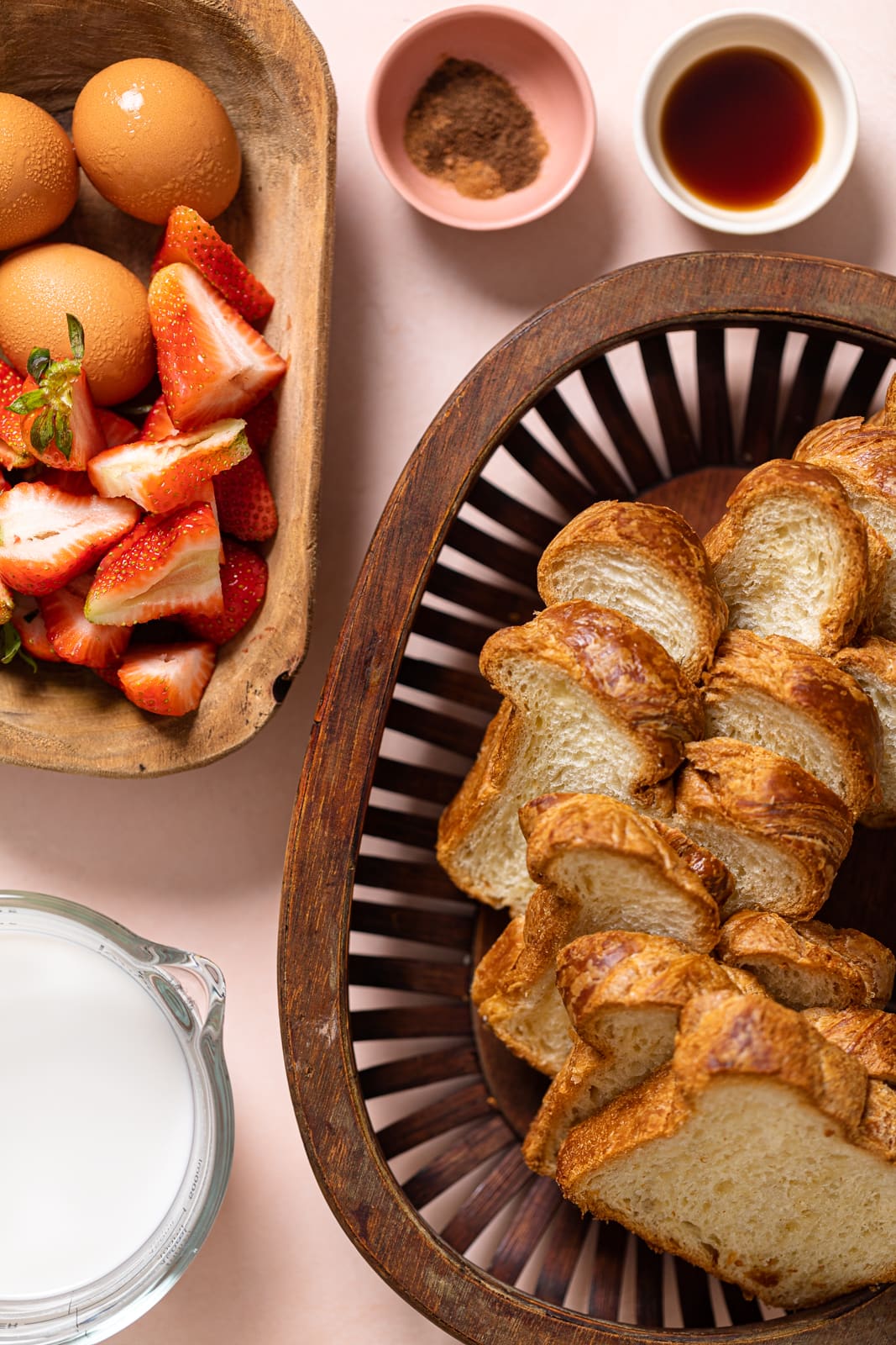 Ingredients for a Dairy-Free Strawberry French Toast Trifle including egg, bread, and strawberries