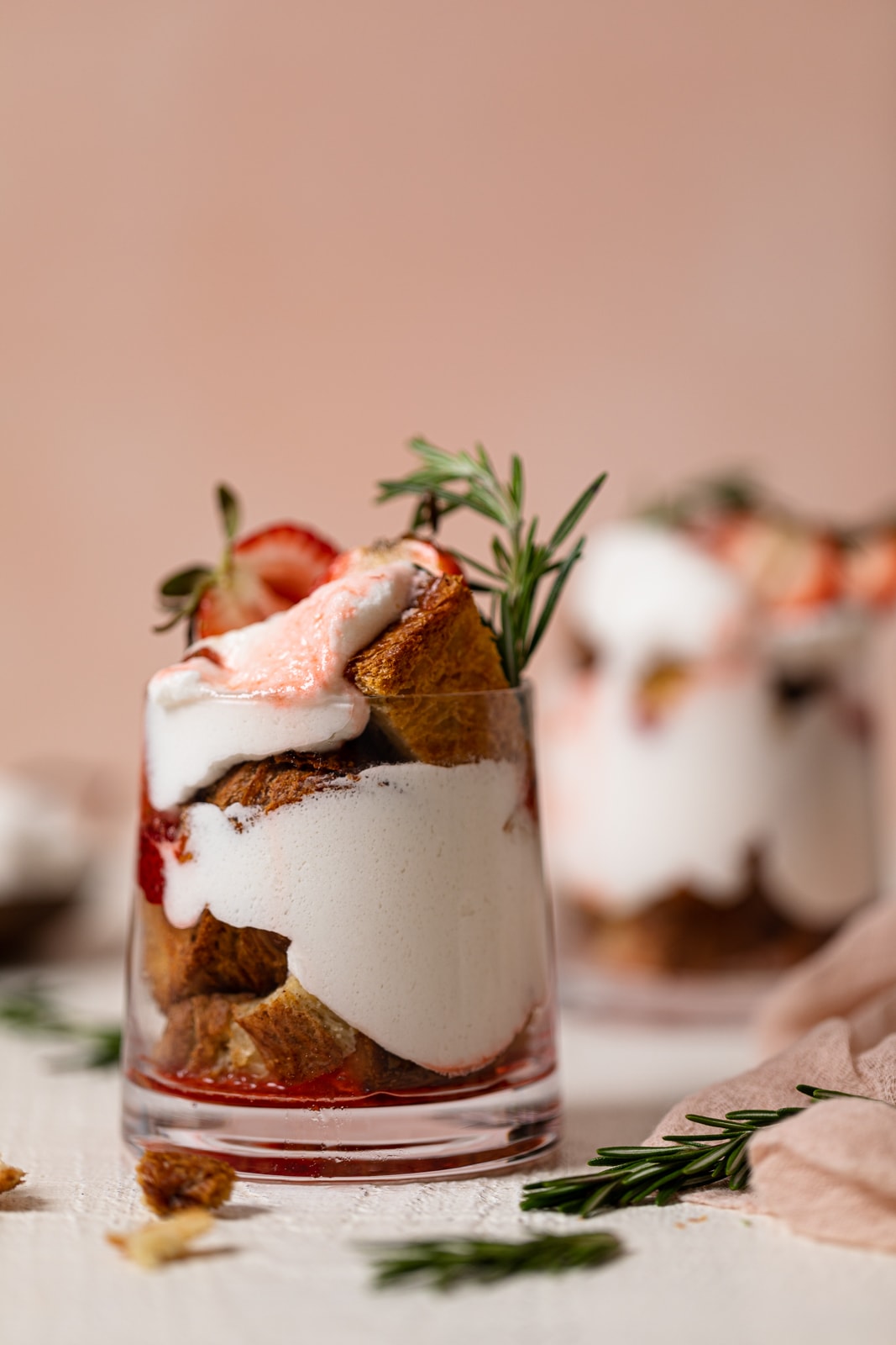 Glass of Dairy-Free Strawberry French Toast Trifle topped with rosemary sprigs