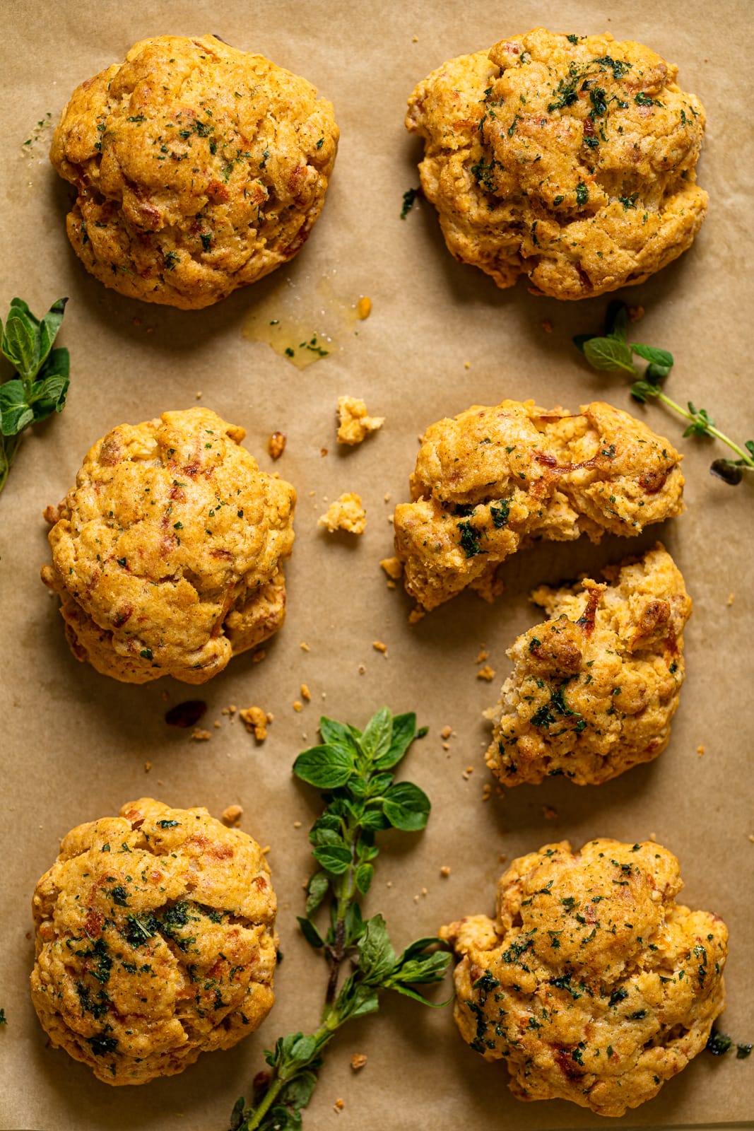 Gluten-Free Cheddar Bay Biscuits on parchment paper with herbs