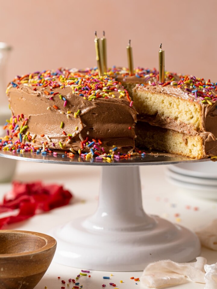 Vanilla Birthday Cake with Chocolate Frosting with a slice pulled out