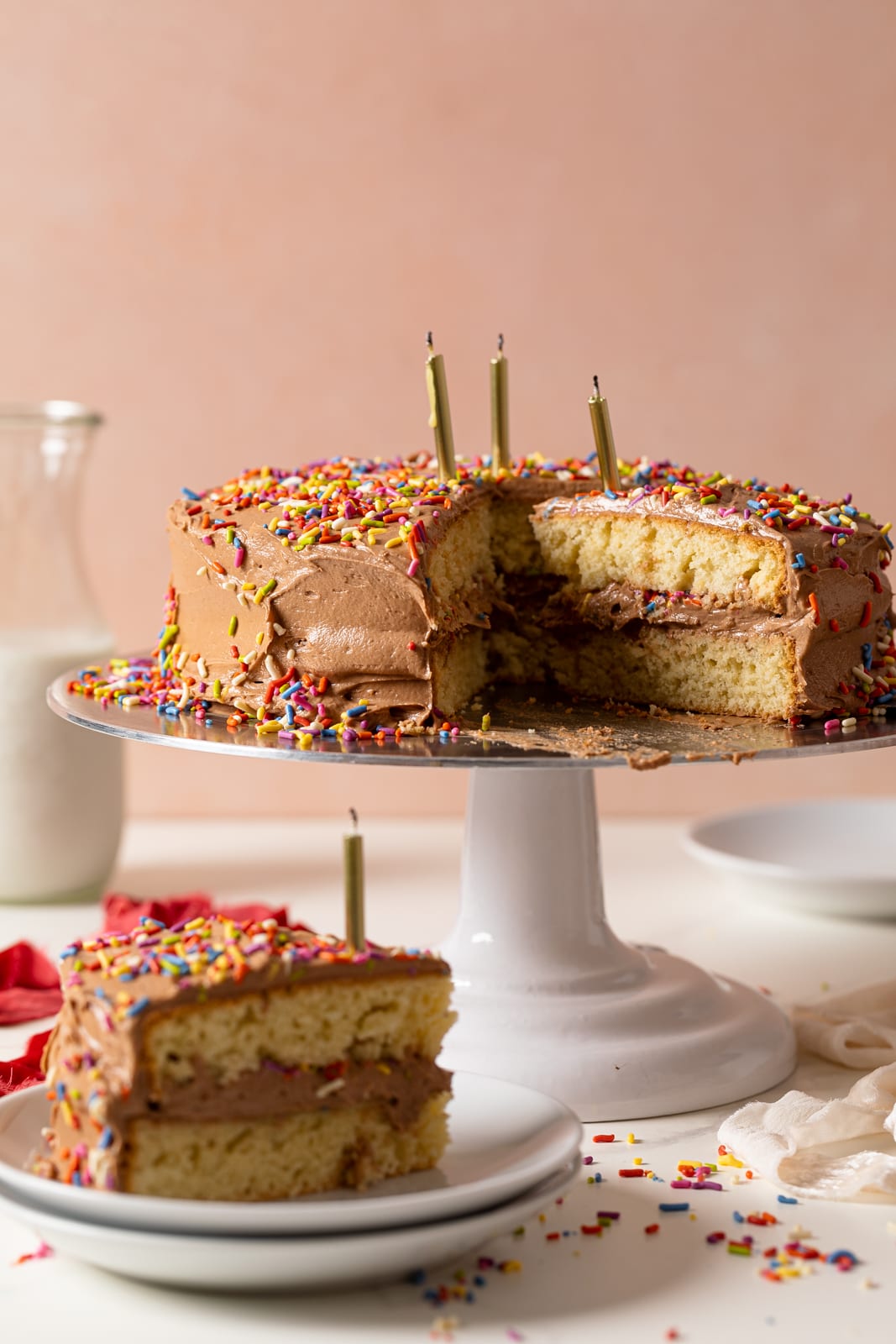 Vanilla Birthday Cake with Chocolate Frosting with a slice put on a plate