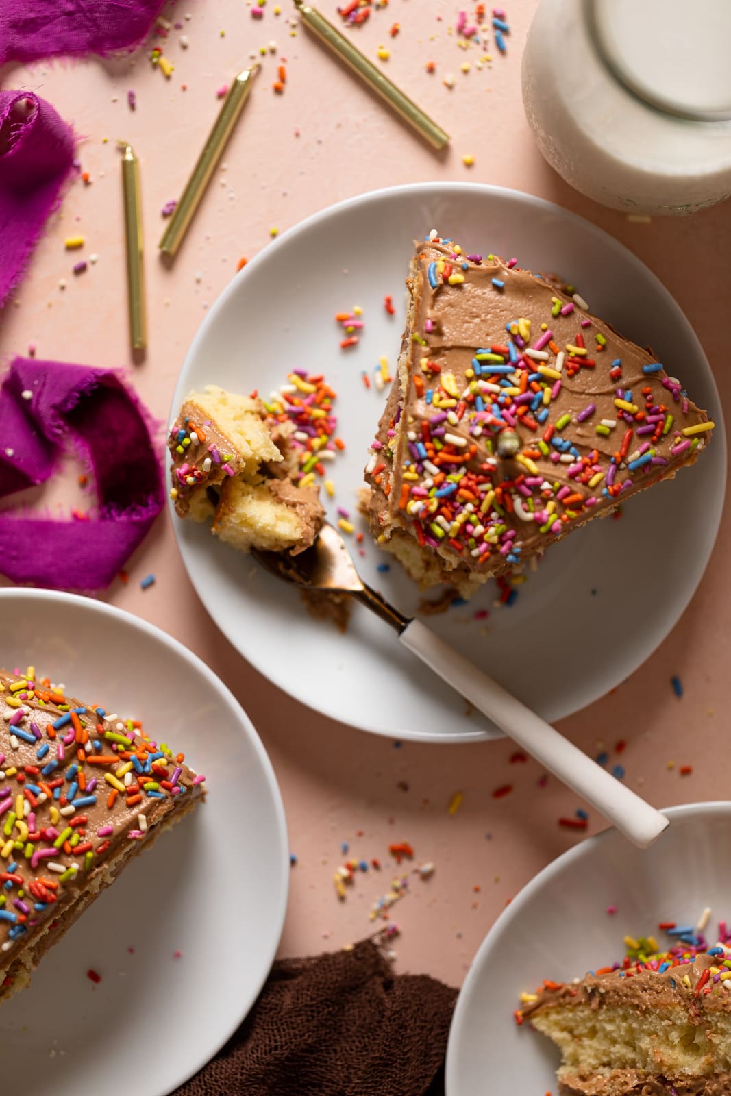 Slice of Vanilla Birthday Cake with Chocolate Frosting with a fork